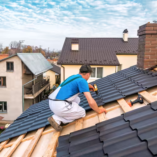 Équipe de couvreurs professionnels posant une toiture neuve sur une maison moderne